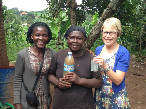 Sarah holds her drinking water before filtration and Angela holds the filtered water
